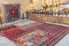 Bukhara, Uzbekistan, Central Asia. Rugs and traditional metal ware displayed for sale in Bukhara. Art Print